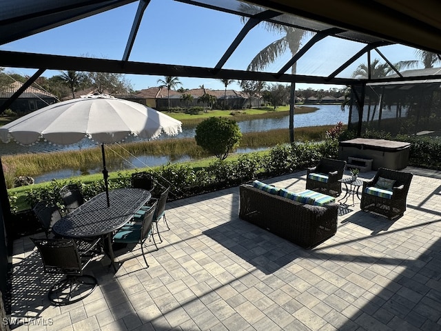 view of patio / terrace with a lanai and a water view