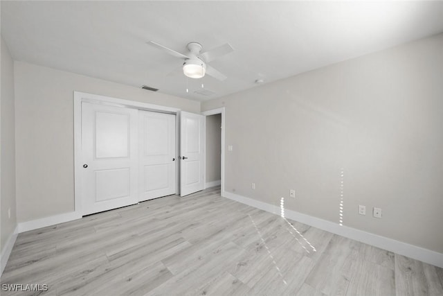 unfurnished bedroom featuring baseboards, light wood finished floors, and a closet