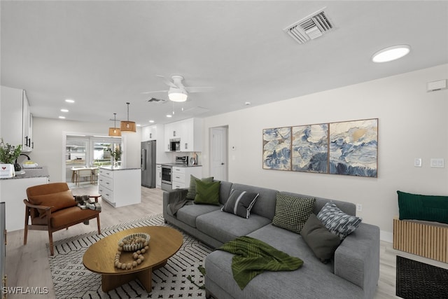 living room with light wood finished floors, ceiling fan, and recessed lighting