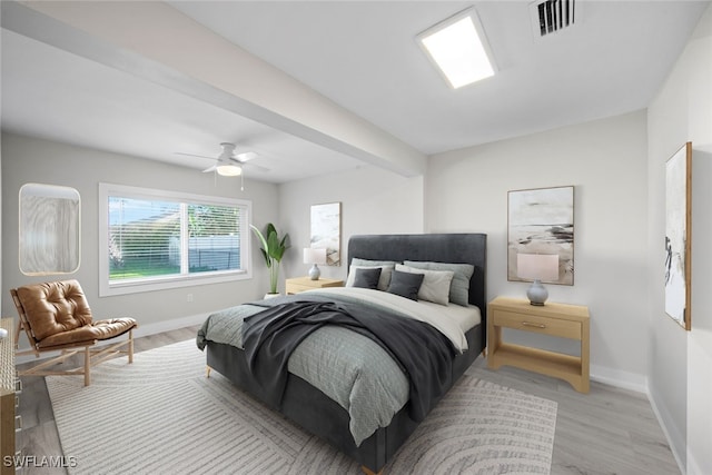 bedroom with light wood-type flooring, ceiling fan, and beamed ceiling