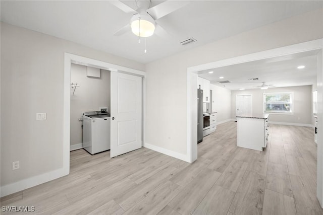 unfurnished living room with washer / dryer, ceiling fan, light wood-type flooring, baseboards, and recessed lighting