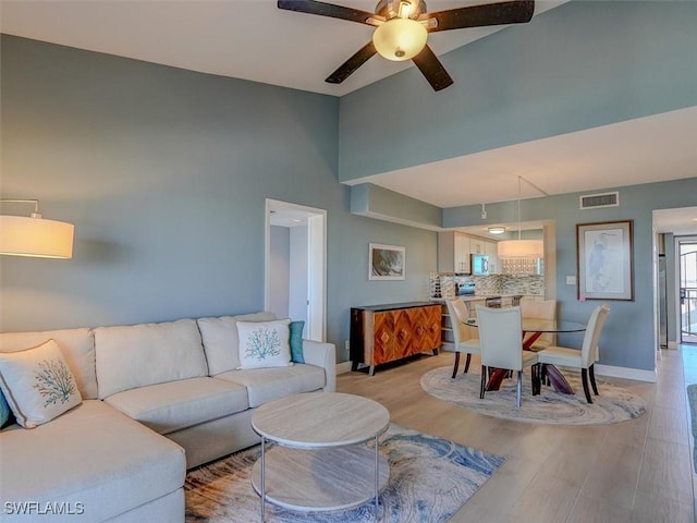 living room with light wood-type flooring and ceiling fan