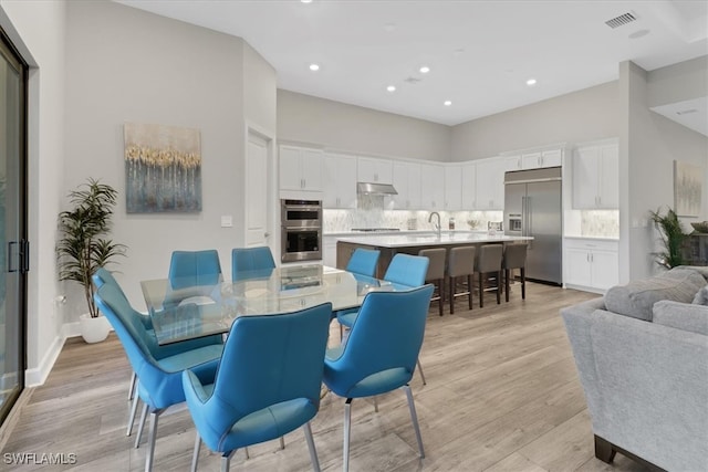 dining area featuring sink and light hardwood / wood-style floors