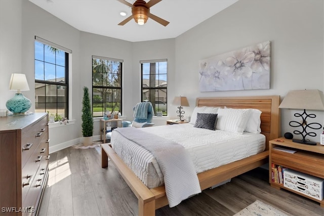 bedroom featuring ceiling fan, wood finished floors, and baseboards