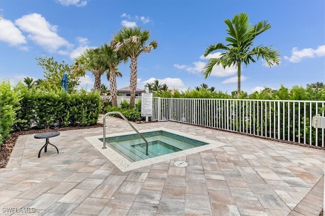 view of pool with a patio area, fence, and a community hot tub