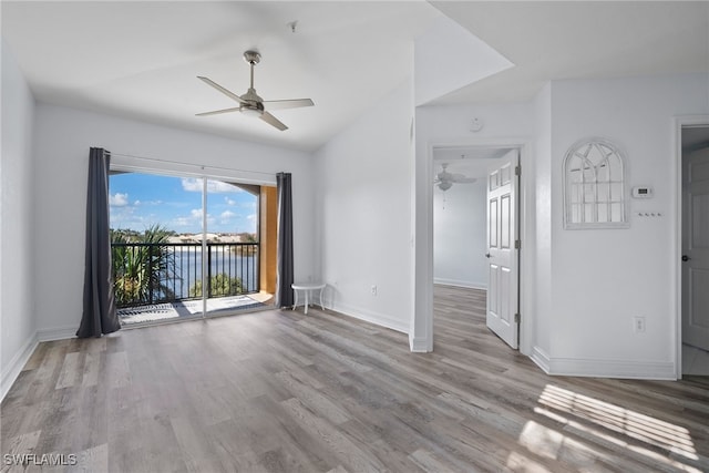 empty room featuring light hardwood / wood-style floors, a water view, and ceiling fan