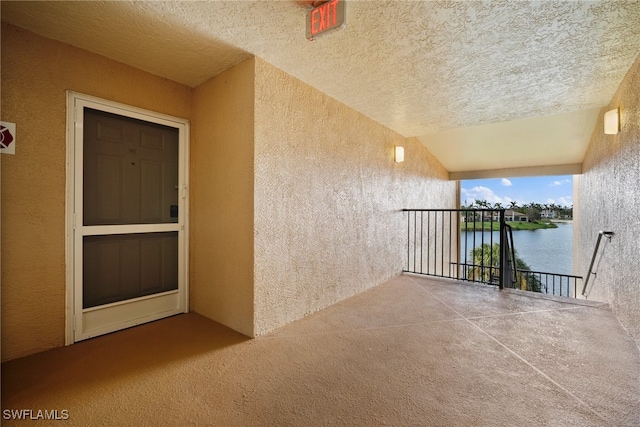 view of patio with a water view and a balcony