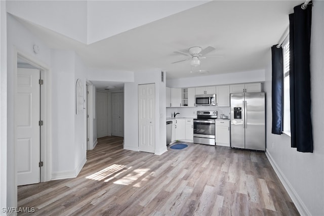 kitchen with white cabinetry, light wood-type flooring, appliances with stainless steel finishes, and ceiling fan