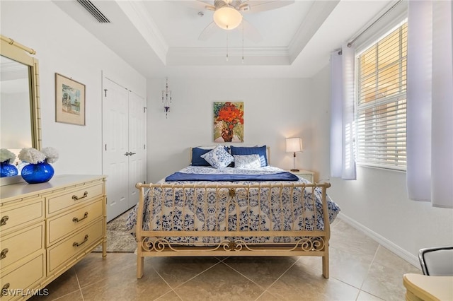 bedroom featuring a raised ceiling, ceiling fan, light tile patterned floors, and ornamental molding