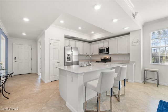 kitchen featuring a center island with sink, white cabinets, sink, and stainless steel appliances