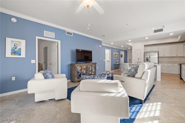 tiled living room with ceiling fan and crown molding