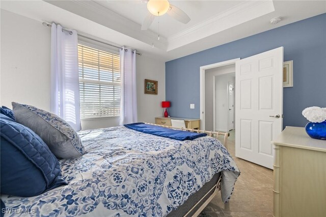 bedroom featuring ceiling fan, light tile patterned floors, crown molding, and a tray ceiling