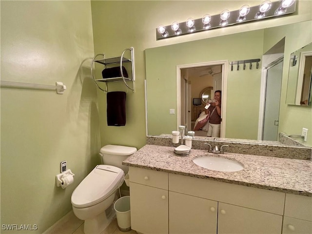 bathroom featuring tile patterned floors, toilet, vanity, and walk in shower