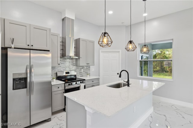 kitchen featuring a kitchen island with sink, stainless steel appliances, sink, and wall chimney range hood