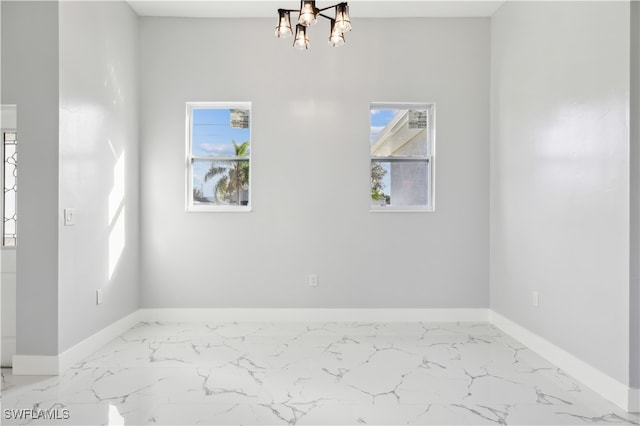 unfurnished room featuring a wealth of natural light and an inviting chandelier