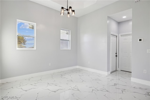 unfurnished room featuring an inviting chandelier