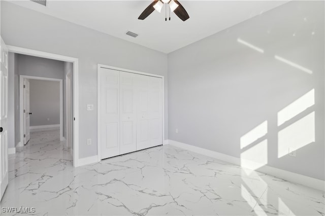 unfurnished bedroom with ceiling fan and a closet