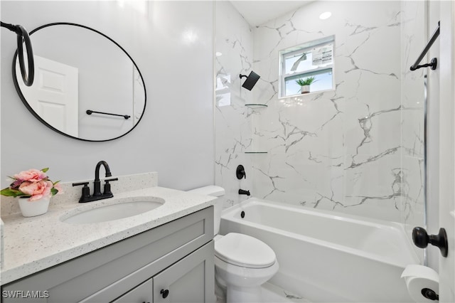 full bathroom featuring tiled shower / bath, vanity, and toilet