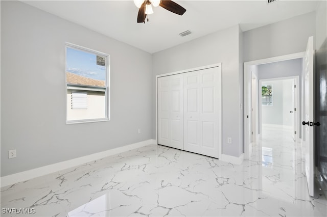 unfurnished bedroom featuring ceiling fan and a closet