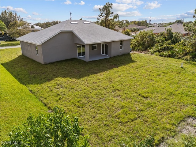 back of house featuring a patio and a yard