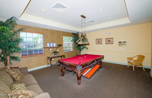 game room with a tray ceiling, pool table, and dark carpet