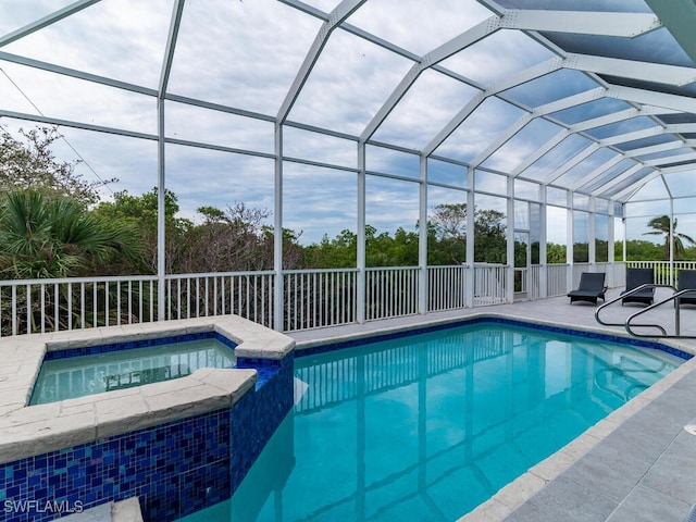 view of swimming pool with a patio area, an in ground hot tub, and glass enclosure