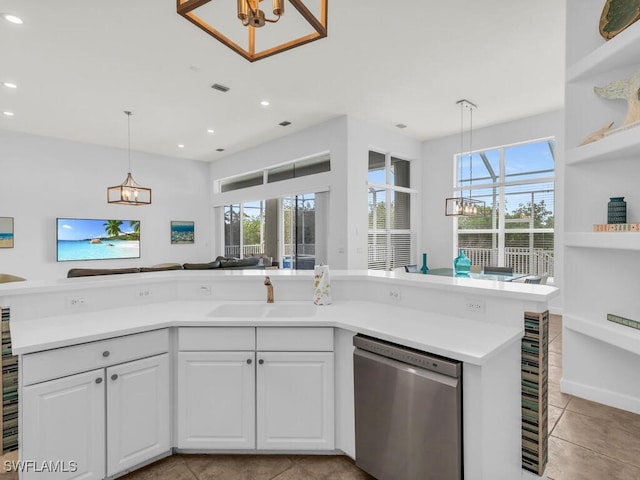 kitchen featuring sink, light tile patterned flooring, stainless steel dishwasher, a chandelier, and white cabinetry