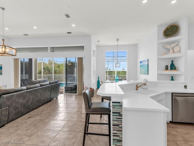 kitchen with sink, a healthy amount of sunlight, dishwasher, and pendant lighting