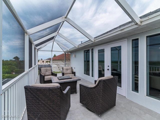 view of patio with an outdoor living space with a fire pit and glass enclosure