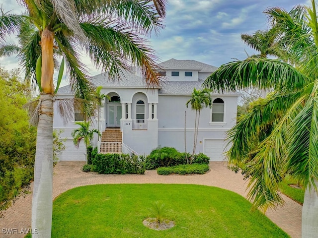 view of front facade featuring a front yard, a garage, and covered porch