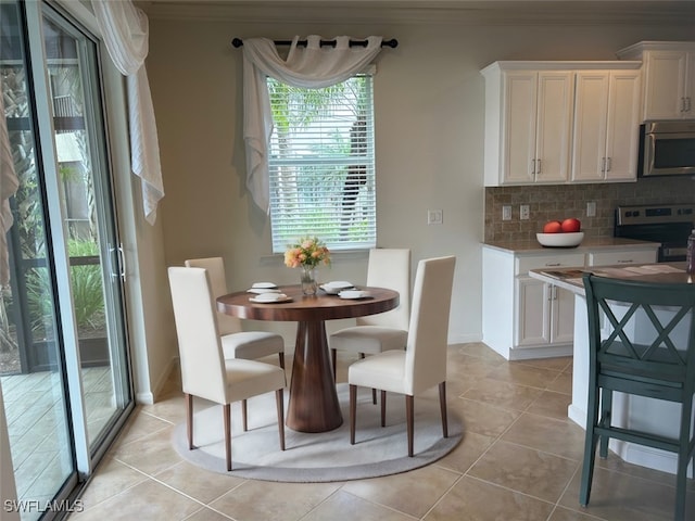 dining area featuring crown molding and light tile patterned floors