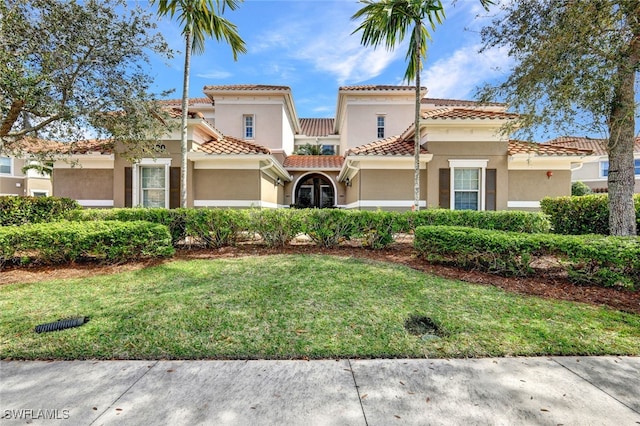 mediterranean / spanish-style home with a front lawn