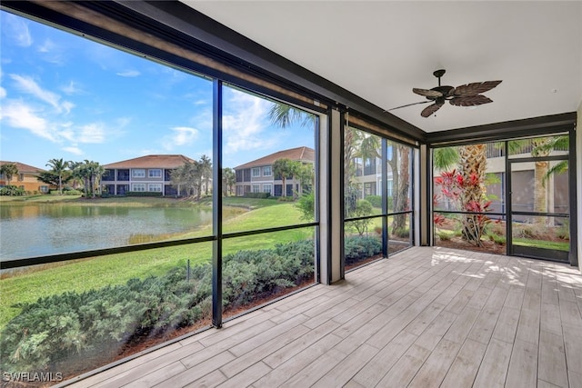 unfurnished sunroom featuring a water view and ceiling fan