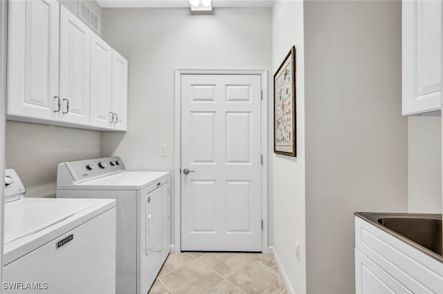 laundry room with light tile patterned flooring, washing machine and dryer, and cabinets