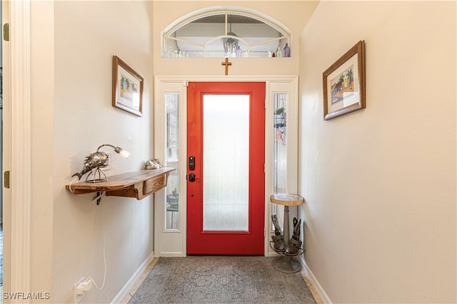 entryway with carpet floors and an inviting chandelier