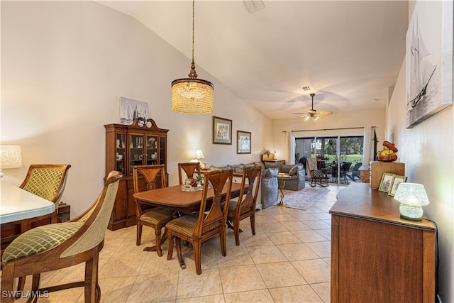 tiled dining area featuring ceiling fan and vaulted ceiling