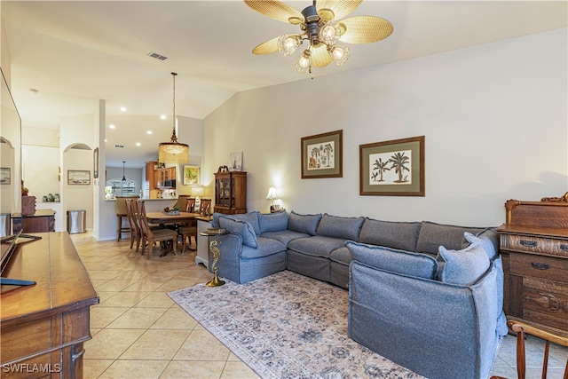 living room featuring lofted ceiling, light tile patterned flooring, and ceiling fan