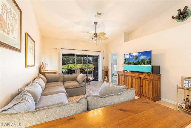 living room with lofted ceiling, light tile patterned floors, and ceiling fan