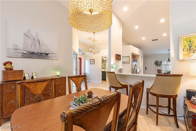 dining area featuring a notable chandelier, light tile patterned floors, and vaulted ceiling