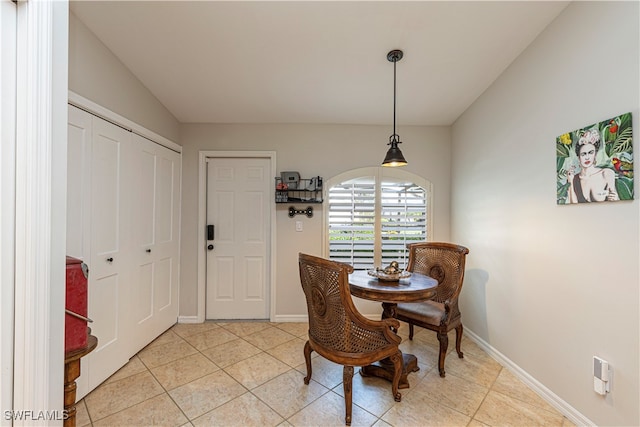 tiled dining area featuring vaulted ceiling