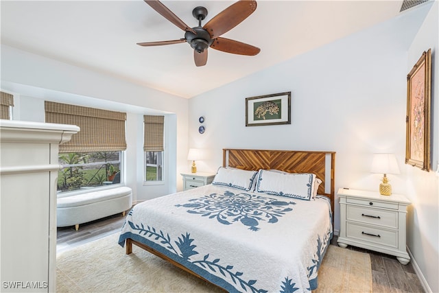 bedroom with light hardwood / wood-style floors, lofted ceiling, and ceiling fan