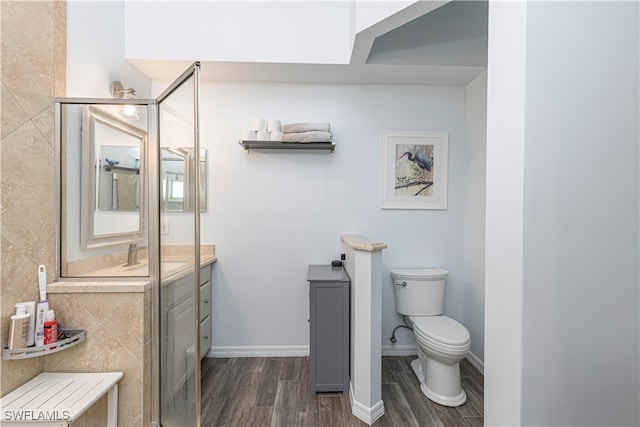 bathroom with toilet, hardwood / wood-style floors, vanity, and tile walls