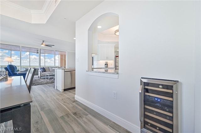 interior space featuring wine cooler, white cabinets, ceiling fan, light hardwood / wood-style flooring, and dishwasher