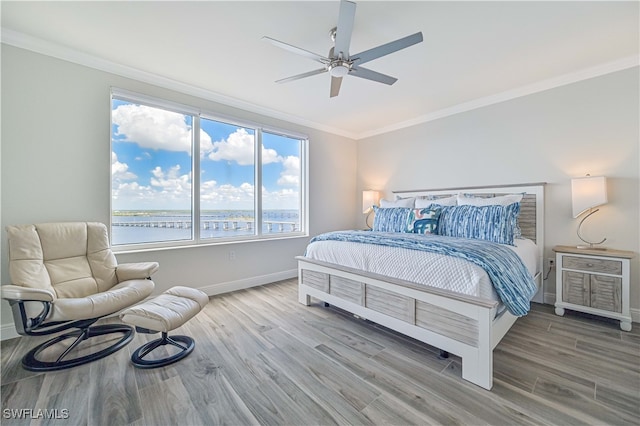 bedroom featuring a water view, ceiling fan, multiple windows, and hardwood / wood-style floors