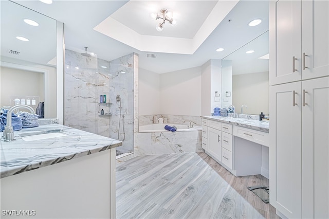 bathroom with vanity, independent shower and bath, and hardwood / wood-style floors