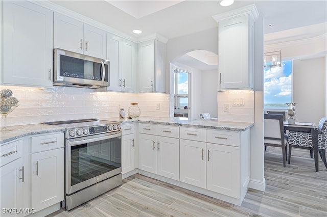 kitchen with white cabinets, light hardwood / wood-style flooring, stainless steel appliances, and plenty of natural light