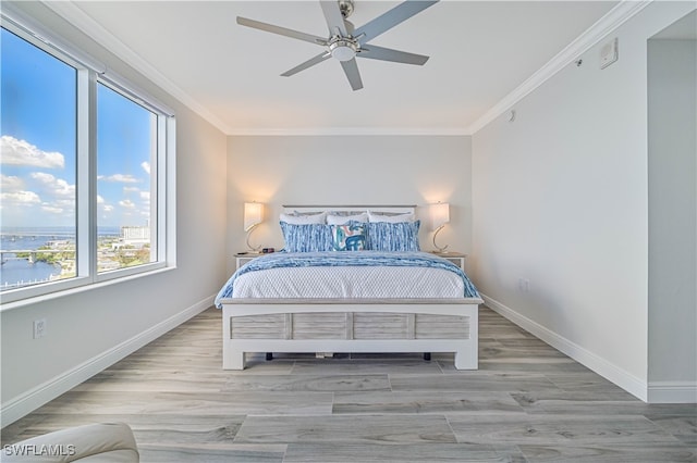 bedroom with a water view, ceiling fan, crown molding, and light hardwood / wood-style floors