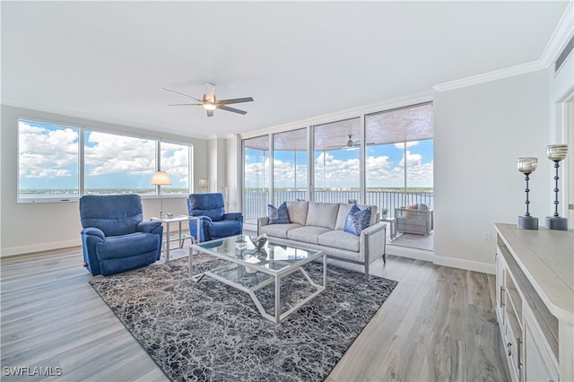 living room featuring crown molding, a wealth of natural light, and light hardwood / wood-style floors