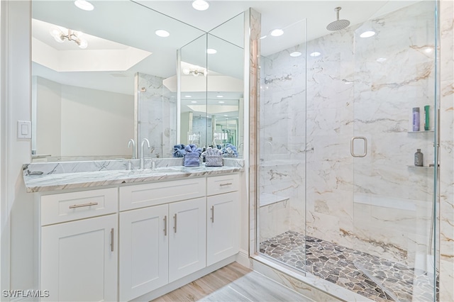 bathroom featuring vanity, a shower with shower door, and wood-type flooring