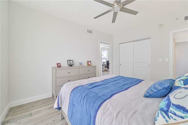 bedroom with a closet, light hardwood / wood-style floors, and ceiling fan